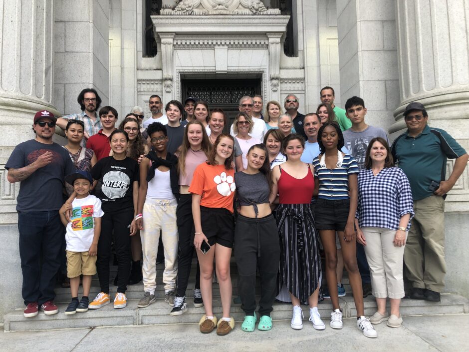 A group photo showing students, their families, and chaperones before leaving for France.