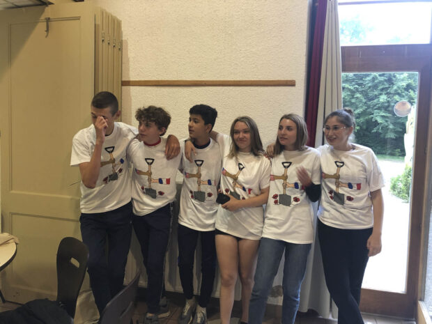 French students posing for a photo in the t-shirts the American students brought for them.